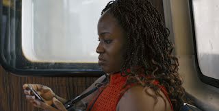 close up of side of woman's face as she looks at her phone