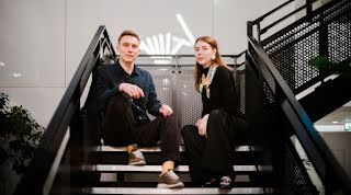 One Man and Woman sit on a stairs.